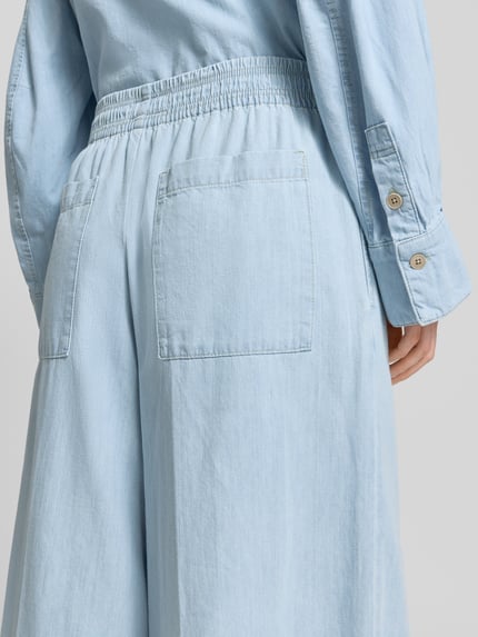 Vrouwenmodel draagt stoffen broek van puur katoen in denimlook, wide fit, elastische band, model 'Ceiling' van Drykorn, detailopname rugaanzicht.