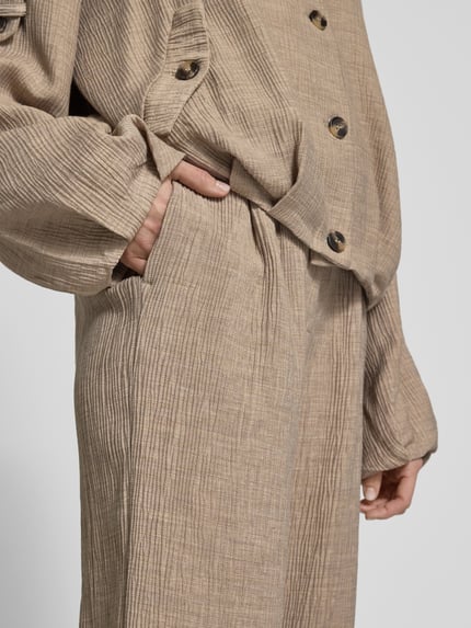 Frauenmodel trägt Stoffhose aus Viskose-Mix mit elastischem Bund von YAS, beige, strukturierte Oberfläche, Nahaufnahme Oberkörper, Modell 'RINA', Wide Leg, Damen, Stretch-Anteil, Bundweite 38 cm, Innenbeinlänge 78 cm.