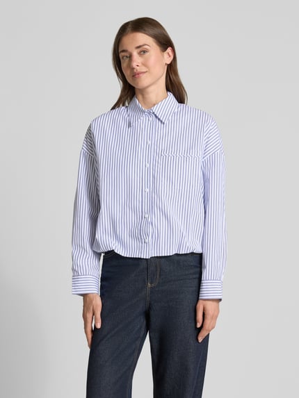 Vrouwenmodel draagt blouse met oversneden schouders van Rich & Royal in blauw-witte strepen, puur katoen, regular fit, overhemdkraag, knoopsluiting, borstzak, ruglengte maat 36: 51 cm, mouwlengte maat 36: 47 cm. Ganzlichaamsaanzicht van voren.
