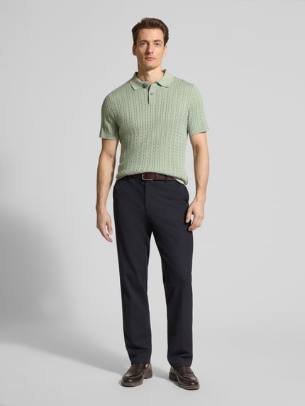 Männermodel trägt Slim Fit Poloshirt in Strick-Optik von Christian Berg Men in zartem Grün, reine Baumwolle, Ganzkörperansicht von vorne.