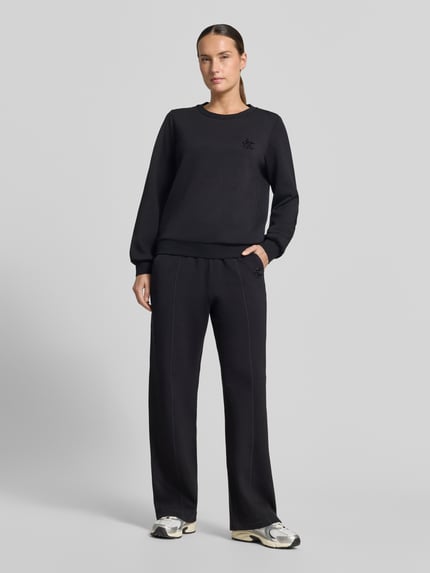 Vrouwenmodel draagt zwart Relaxed Fit sweatshirt uit viscosemix Model 'Felpa' van Liu Jo met siersteentjes, elastische boorden, Ganzkörperansicht von vorne