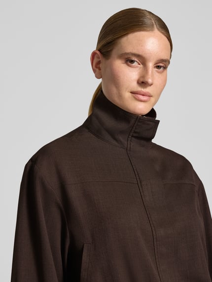 Frauenmodel trägt Regular Fit Jacke mit Stehkragen Modell 'Felicity' von Neo Noir in Dunkelbraun, glatte Textur, Nahaufnahme Oberkörper.