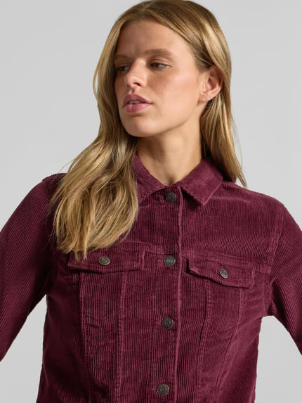 Frauenmodel trägt Jacke aus Cord mit Brusttaschen Modell 'DEBRA' von NOISY MAY®, bordeauxrot, sichtbare Knopfleiste, Nahaufnahme Oberkörper.