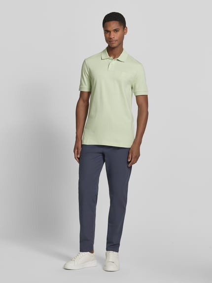 Männermodel trägt Slim Fit Poloshirt aus Baumwoll-Mix Modell 'PASSENGER' von BOSS Orange, Optik: Unifarben, Logo-Patch, Kragenform: Polokragen, 2-Knopf-Verschluss, Ärmelform: Kurzarm, Material: Baumwoll-Mix, Ganzkörperansicht von vorne.