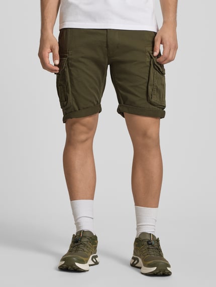 Männermodel trägt Shorts mit Cargotaschen Modell 'CREW SHORT' von Alpha Industries in Olivgrün, Regular Fit, Ganzkörperansicht von vorne.