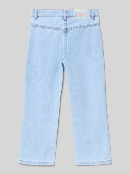 Mädchen trägt Jeans mit aufgesetzten Taschen und Ziersteinbesatz von BILLIEBLUSH in Hellblau, reine Baumwolle, Regular-Fit, Ganzkörperansicht Rückansicht.