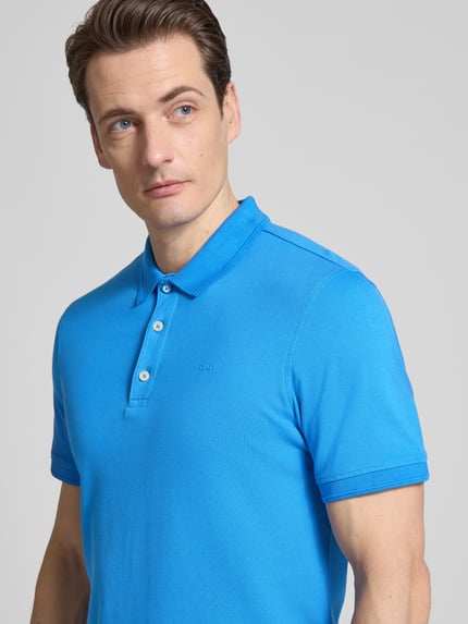 Männermodel trägt Slim Fit Poloshirt aus Baumwoll-Mix Modell 'Pete' von BRAX in Blau, Polokragen, Nahaufnahme Oberkörper, Rückenlänge 71 cm bei Größe M.