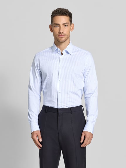 Männermodel trägt Regular Fit Businesshemd aus Baumwoll-Mix von BOSS mit Optik:Allover-Muster, Kentkragen, einreihige Knopfleiste, Ganzkörperansicht von vorne.
