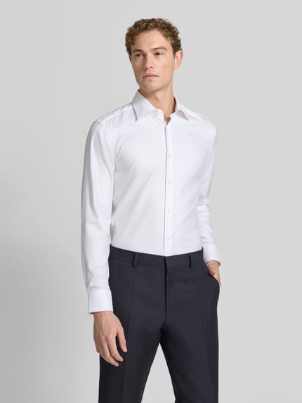 Männermodel trägt weißes Slim-Fit Businesshemd aus reiner Baumwolle Modell 'H-HANK-K' von BOSS, Herren Businesshemd, Ganzkörperansicht von vorne.