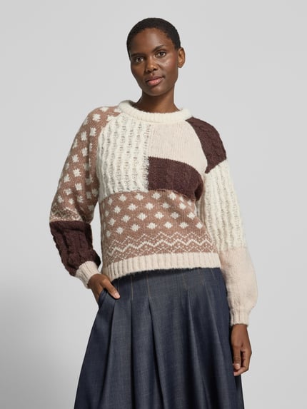 Frauenmodel trägt Pullover mit Strukturmix von VERO MODA, mehrfarbig, Patchwork mit Zopf- und Punktmuster, Strick, Nahaufnahme Oberkörper.