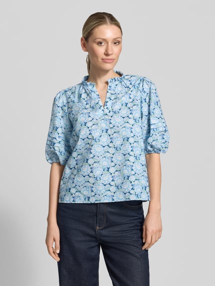 Vrouwenmodel draagt Bluse mit Serafino-Kragen und Ballonärmeln van Rich & Royal in blauw-wit bloemenpatroon, puur katoen, loose fit, ruglengte 57 cm, mouwlengte 39 cm, geheel vooraanzicht.