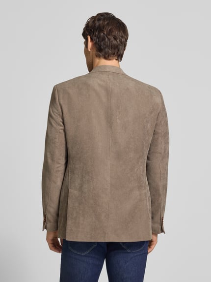 Männermodel trägt Sakko mit Pattentaschen und Reverskragen Modell 'Theo' von Carl Gross in Cord, Ganzkörperansicht Rückansicht.