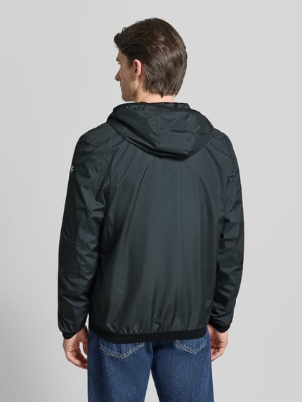 Männermodel trägt schwarze Herren Jacke mit Kapuze Modell 'KOS' von Killtec, Gerader-Schnitt, Ganzkörperansicht Rückansicht.