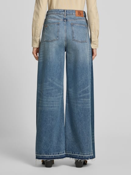 Frauenmodel trägt Wide Leg Jeans mit Fransensaum Modell 'MISLAV' von ba&sh, reine Baumwolle, blau, Gesäßtaschen, Ganzkörperansicht Rückansicht.