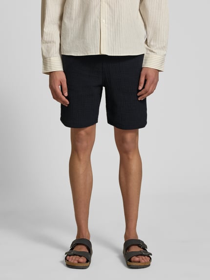 Mannenmodel draagt Shorts met structuurpatroon model 'AIDEN' van Jack & Jones, katoenmix, straight fit, steekzakken, elastische band met tunnelkoord, zwart, bandwijdte maat M 40 cm, binnenbeenlengte maat M 21 cm, vooraanzicht tot knieën.