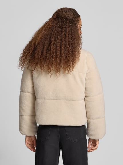 Modelka nosi kremową kurtkę PEGADOR Relaxed Fit w imitacji futerka Model 'GEORGIA', stójka, detal z logo, długość tyłu 57 cm, szerokość ramion 41 cm, szerokość w rozmiarze S 51 cm, długość rękawów 63 cm, widok całej sylwetki z tyłu.