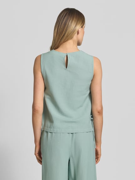 Frauenmodel trägt Blusentop aus Viskose-Mix mit seitlicher Schnürung von Vila in Mint, leichter Stoff, Straight Fit, Modell PRISILLA, Ganzkörperansicht Rückansicht. Rückenlänge bei Größe 36: 54 cm, Leinen-Viskose-Anteil, Rundhalsausschnitt.