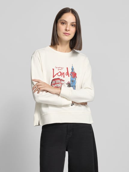 Frauenmodel trägt Sweatshirt mit Motiv-Print und Rundhalsausschnitt von Milano Italy, cremeweiß mit buntem Print, Baumwoll-Mix, Relaxed Fit, Ganzkörperansicht von vorne.