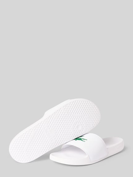Produktfoto, Badeschuhe mit Logo Print Modell 'SERVE SLIDE' von Lacoste, białe, jednokolorowe, zaokrąglony nosek, płaski obcas, otwarty, teksturowana podeszwa