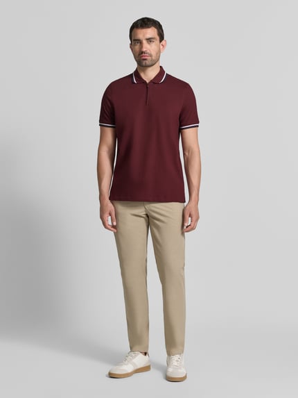 Männermodel trägt Slim Fit Poloshirt mit Kontraststreifen und Reißverschluss von MCNEAL, Baumwoll-Elasthan-Mix, Ganzkörperansicht von vorne.