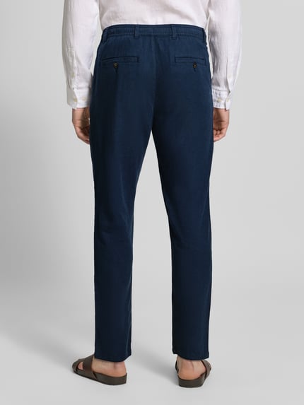 Männermodel draagt Regular Fit broek van katoen-linnen-mix model 'BRODY' van SELECTED HOMME in effen kleuren, gemêleerde look, labelapplicatie, regular fit, dropped rise, slim tapered vanaf de knie, met riemlussen, knoop- en ritssluiting, boord met tunnelkoord, achterzakken en steekzakken. Ganzkörperansicht Rückansicht.