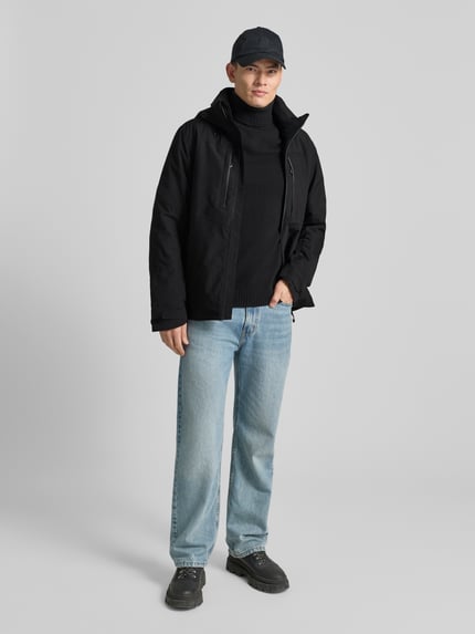 Männermodel trägt Jacke mit Kapuze von Icepeak in Schwarz, Material-Mix, Regular-Fit, Reißverschluss, Reißverschlusstaschen, Ganzkörperansicht von vorne. Rückenlänge bei Größe 50: 77 cm, Schulterbreite: 47 cm, Brustweite: 58 cm, Ärmellänge: 72 cm.