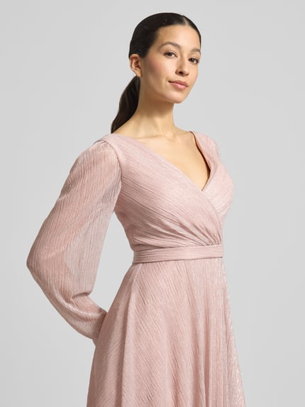 Vrouwenmodel draagt Regular Fit Jurk in wikkellook van TROYDEN COLLECTION met glitter mesh, v-hals, getailleerd, lange mouwen, borstwijdte 37 cm, ruglengte 90 cm, naadritssluiting, effen roze kleur, textuur met fijne plooien. Nahaufnahme bovenlichaam.