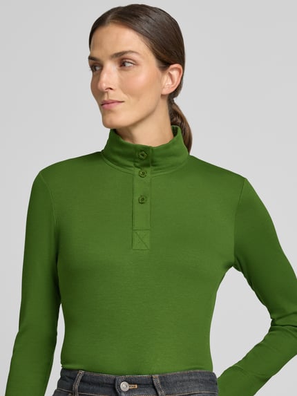 Vrouwenmodel draagt Slim Fit Longsleeve uit katoenmix van Marc Cain, elastisch, staande kraag, knoopsluiting, groene kleur, detailopname bovenlichaam.