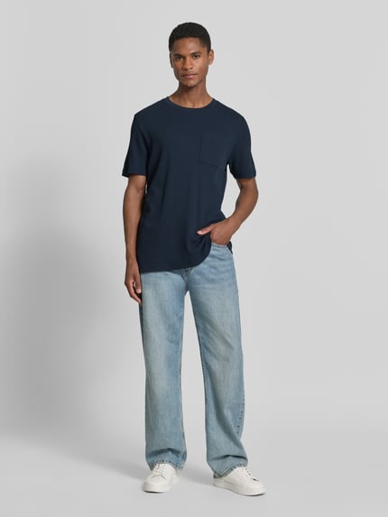 Männermodel trägt Regular Fit T-shirt aus katoenmix van s.Oliver RED LABEL in effen kleuren, ronde hals, korte mouw, borstzak, piqué, ganzkörperansicht van voren.
