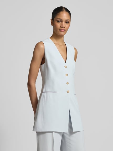 Frauenmodel trägt Slim Fit Longblazer ohne Ärmel Modell 'JULINIAL' von BOSS in Hellblau mit goldenen Knöpfen, reine Viskose, Nahaufnahme Oberkörper.