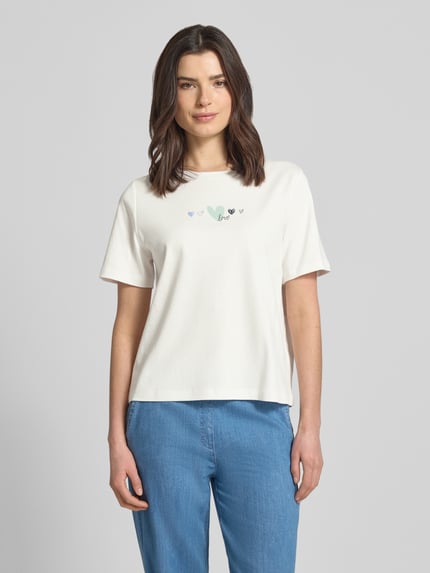 Frauenmodel trägt Relaxed Fit T-Shirt aus reiner Baumwolle von Tom Tailor, Optik: Unifarben, Motiv-Print, Rundhals, Kurzarm, Ganzkörperansicht von vorne.