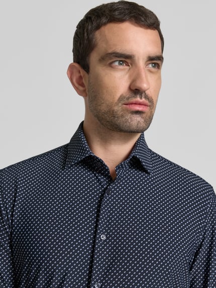 Männermodel trägt Slim Fit Business-Hemd mit Kentkragen von Jake*s, elastischer Material-Mix, feines Punktmuster, Nahaufnahme Oberkörper.