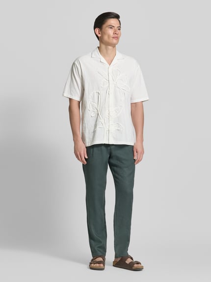 Männermodel trägt Tapered Leinenhose mit Gürtelschlaufen Modell 'OSBY JOGGER' von Marc O'Polo, Unifarben, Bundfalte, reines Leinen, Ganzkörperansicht von vorne.