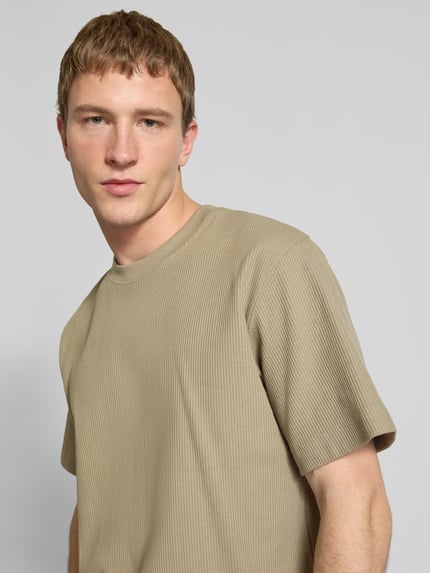 Męski model nosi T-shirt mit Ripp-Optik Modell 'HARRISON' von JACK & JONES, bawełna, luźny krój, okrągły dekolt, długość tyłu 68 cm, zbliżenie na górną część ciała