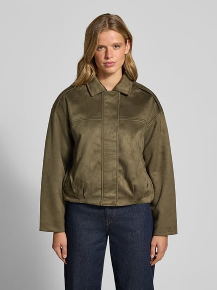 Frauenmodel trägt Regular Fit Blouson in Leder-Optik Modell 'AMBER' von ONLY, olivgrün mit glatter Textur, Damen Bomberjacke, Ganzkörperansicht von vorne.
