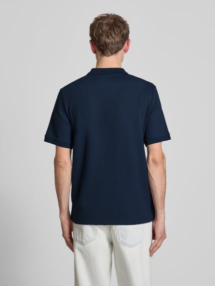 Männermodel trägt Regular Fit Poloshirt mit Reißverschluss Modell 'AUSTIN' von Jack & Jones, Strukturmuster, dunkelblau, Ganzkörperansicht Rückansicht.
