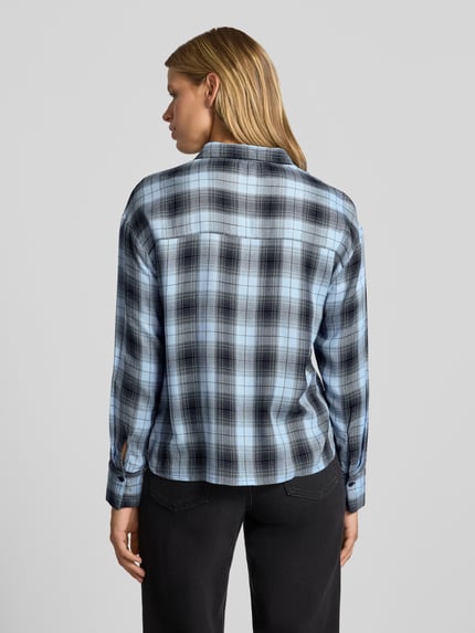 Frauenmodel trägt Regular Fit Hemdbluse aus reiner Viskose Modell 'RILEY' von ONLY, blau-schwarz kariert, weiche Textur, Ganzkörperansicht Rückansicht, Damen Hemdbluse von ONLY.