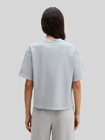 Frauenmodel trägt Boxy Fit T-Shirt aus reiner Baumwolle von Marc O'Polo, Optik: Unifarben, Label-Schriftzug, Ganzkörperansicht Rückansicht.