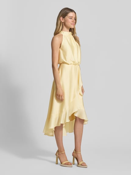 Frauenmodel trägt Neckholder-Cocktailkleid mit Volants von Swing aus Satin in A-Linie, Pastellgelb, Midikleid, Ganzkörperansicht von vorne. Rückenlänge bei Größe 36: 125 cm, Brustweite: 34 cm.