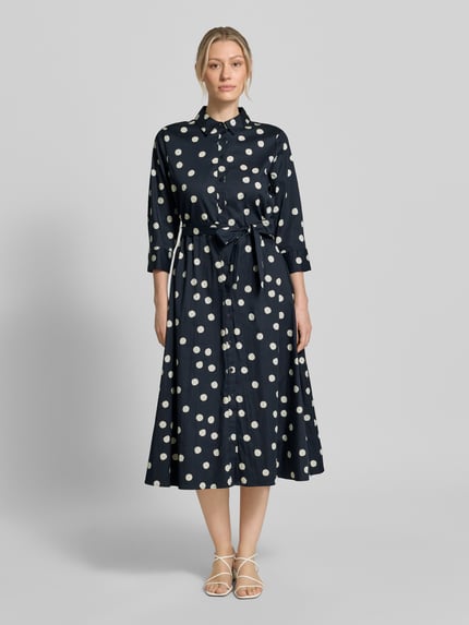 Frauenmodel trägt Regular Fit Blusenkleid aus Baumwoll-Mix von s.Oliver BLACK LABEL, Optik:Allover-Muster mit Polka-Dots, Midi-Länge, Hemdblusenkragen, Knopfleiste, Taillengürtel, Langarm mit Ballonärmel und Manschette, seitliche Eingrifftaschen, ganz in Dunkelblau mit weißen Punkten, glatte Struktur, Ganzkörperansicht von vorne.