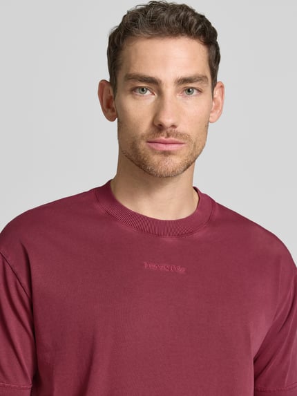 Männermodel trägt Relaxed Fit T-Shirt aus reiner Baumwolle von Marc O’Polo, unifarbenes Jersey, Rundhals, Label-Schriftzug, Nahaufnahme Oberkörper.