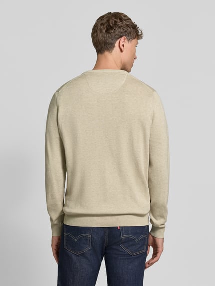 Männermodel trägt Strickpullover mit Label-Strickerei von Fynch-Hatton aus reiner Baumwolle in Beige, gerader Schnitt, Ganzkörperansicht Rückansicht.