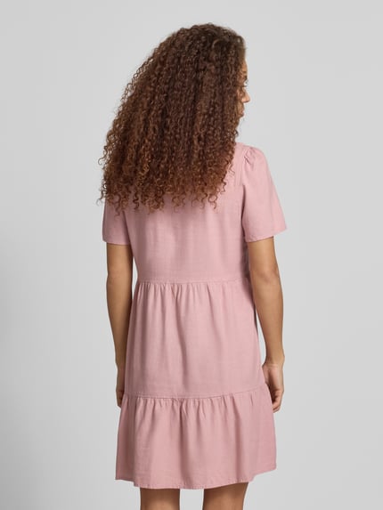 Modelka kobieca ma na sobie A-Linie Freizeitkleid aus Viskose-Leinen-Mix Modell 'TIRI-GOA' od Only, różowy, jednolity, mini, krótki rękaw, widok całej sylwetki z tyłu.