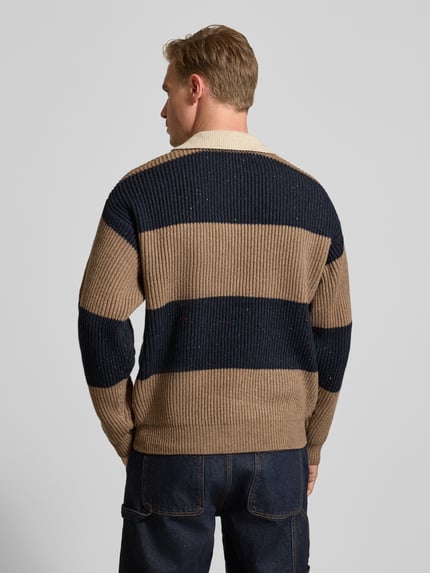 Männermodel trägt Poloshirt mit gerippten Abschlüssen Modell 'Lotu' von WOODBIRD aus Woll-Mix, beige-blau gestreift, lockerer Schnitt, Ganzkörperansicht Rückansicht.