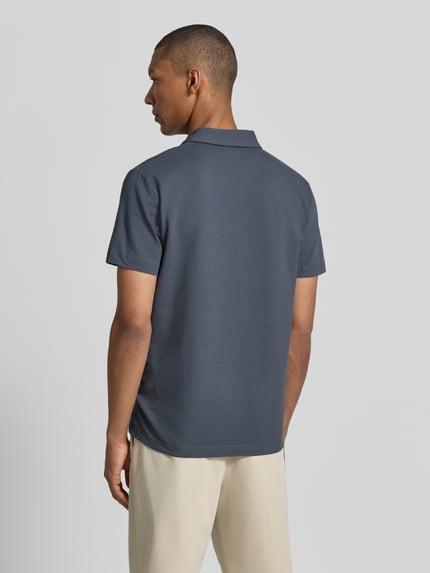Männermodel trägt Regular Fit Poloshirt mit Logo-Stitching von Lerros in Blau mit Strukturmuster aus Baumwoll-Mix mit Stretch-Anteil, Ganzkörperansicht Rückansicht.
