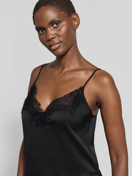 Frauenmodel trägt schwarzes Spitzentop mit V-Ausschnitt Modell 'Brenda' von My Essential Wardrobe aus Satin, Regular Fit, Nahaufnahme Oberkörper.