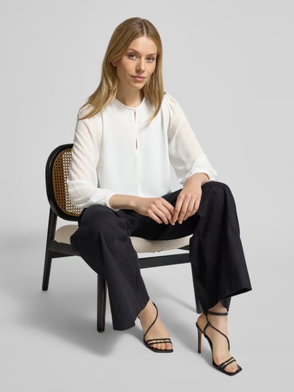 Vrouwenmodel draagt Blusenshirt met Rundhalsausschnitt van Rinascimento, wit, losse pasvorm, lange mouwen, voorkant, halve lichaamsopname.