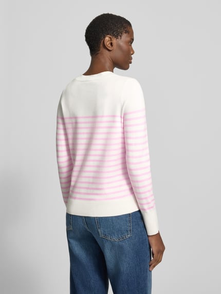 Frauenmodel trägt Pullover mit gerippten Abschlüssen von S.OLIVER CASUAL, weiß-rosa gestreifter Feinstrick, Ganzkörperansicht Rückansicht.