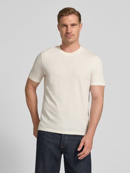 Männermodel trägt Regular Fit T-Shirt mit Rundhalsausschnitt von MCNEAL in Creme, reine Baumwolle, glatte Textur, Ganzkörperansicht von vorne.