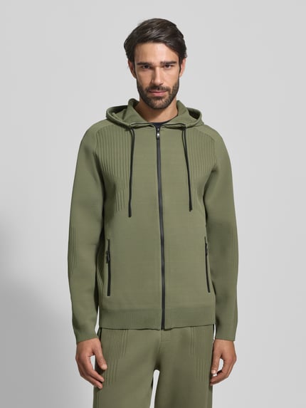 Männermodel trägt Regular Fit Kurtka treningowa z żakardowymi elementami Model 'ACTIVE PUSH' od BOSS Green, jednokolorowy, struktura, wyhaftowane logo, zamek błyskawiczny wodoodporny, kaptur ze ściągaczem, długi rękaw, kieszenie na zamek, całkowity przód.